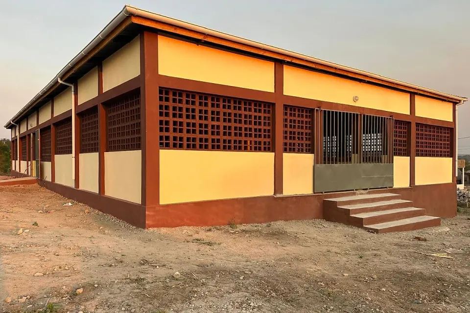 Mercado distrital de Macossa concluído, com paredes amarelas e blocos rendilhados