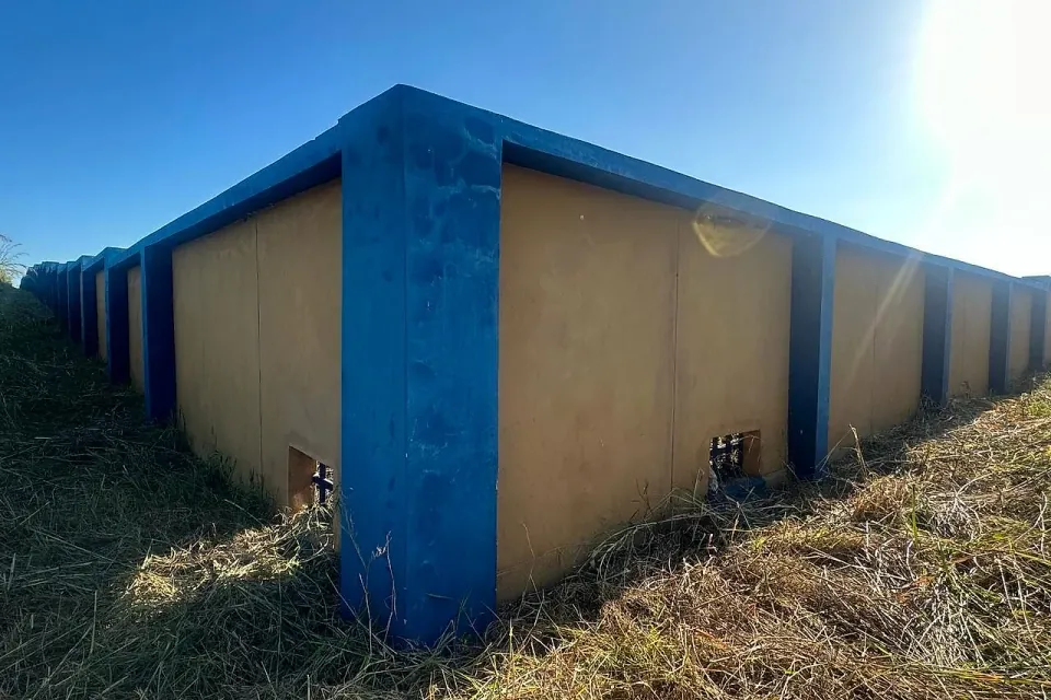 Muro de vedação em betão com pilares azuis do Banco de Moçambique em Chimoio